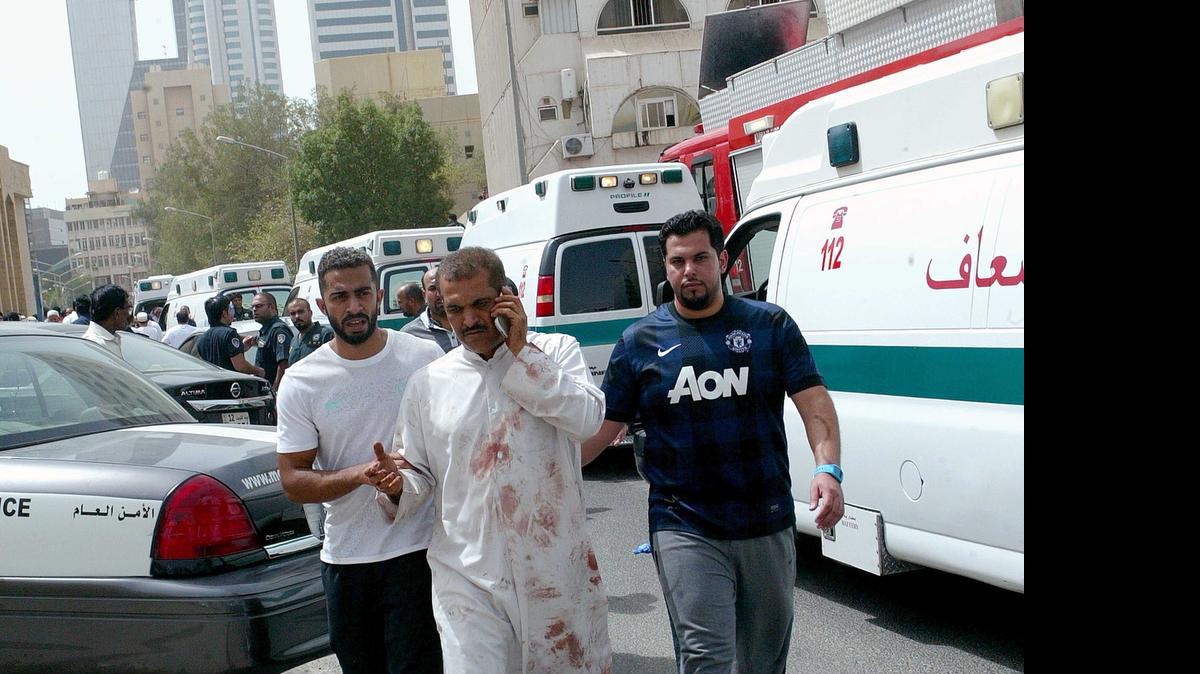 
Kuwaiti men accompany a man with blood-stained clothes at the site of a suicide bombing that targeted the Shiite Al-Imam al-Sadeq mosque after it was targeted by a suicide bombing during Friday prayers on June 26, 2015, in Kuwait City. The Islamic State group-affiliated group in Saudi Arabia, calling itself Najd Province, said militant Abu Suleiman al-Muwahhid carried out the attack, which it claimed was spreading Shiite teachings among Sunni Muslims. AFP PHOTO / YASSER AL-ZAYYATYASSER AL-ZAYYAT/AFP/Getty Images 
