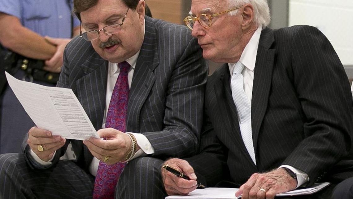 Sen. Fletcher Hartsell, left, reads his indictment with attorney Wade Smith as they wait to appear before a magistrate at the Wake County Detention Center on Tuesday, June 28, 2016 in Raleigh, N.C. Hartsell was indicted by the Wake County grand jury on allegations that he signed false campaign finance reports.