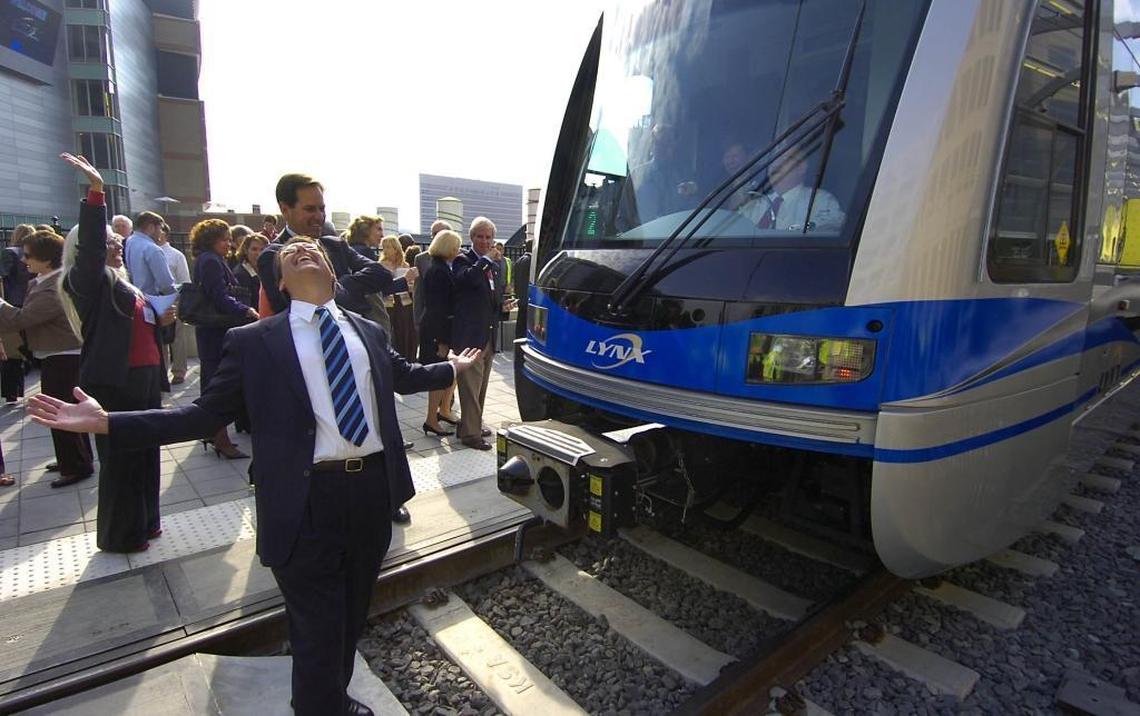 Then Charlotte Mayor Pat McCrory, left, smiles skyward in front of a Lynx light rail train with Ron Tober, then-chief executive of the Charlotte Area Transit System, at the controls during a dedication ceremony in 2007.