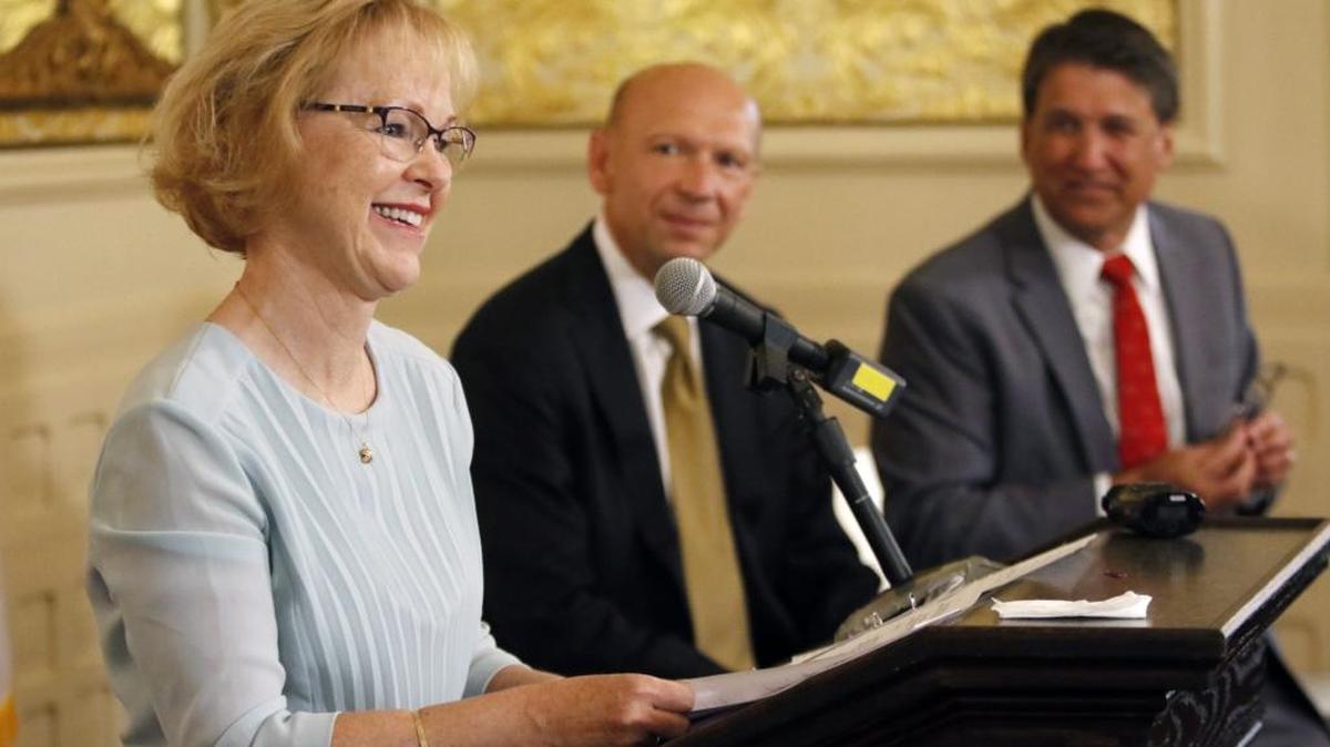 From left, outgoing NC DHHS Secretary Aldona Wos thanks her DHHS staffers in the audience for their hard work as Rick Brajer and NC Governor Pat McCrory listen during a press conference Aug. 5, 2015, at the Governor's Mansion in Raleigh, NC. Wos was the DHHS secretary in 2013 when the state fixed a problem of improper Medicaid payments. Now the federal government says the state owes it $41 million.