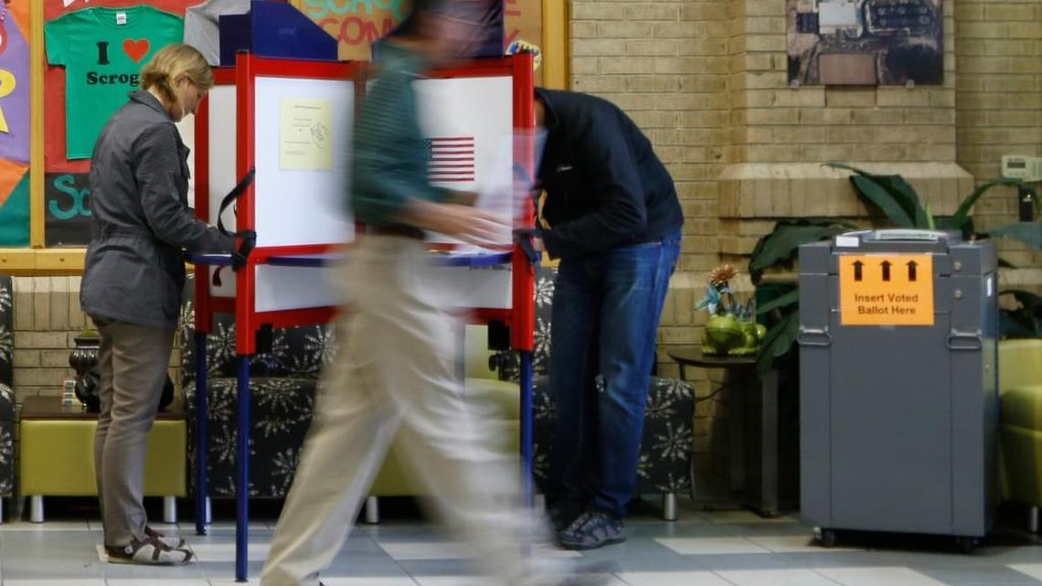 A voter is a blur of motion heading to the tally machine at right,as others vote at the Dogwood Acres precinct at Mary Scroggs Elementary School in Chapel Hill, NC Tuesday, November 3, 2015. Tuesday was Orange County municipal elections day with a mayoral race, voting for school board offices and five bond referendums. Voter turnout among the approximately 2,900 registered voters at Dogwood Acres was very good for Chapel Hill/Carrboro with 160 early or absentee voters, and 330 voters Tuesday by 1pm since the 630am opening of the polls in the Southern Village community of Chapel Hill.