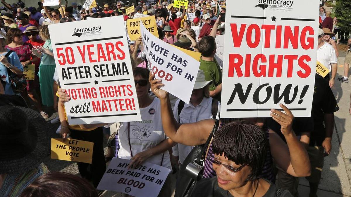 
Demonstrators march through the streets of Winston-Salem, N.C., Monday, July 13, 2015, after the beginning of a federal voting rights trial challenging a 2013 state law. Election law experts say the case could determine how far Southern states can change voting rules after the nation's highest court struck down a portion of the federal Voting Rights Act just weeks before the North Carolina law was passed. (AP Photo/Chuck Burton)
