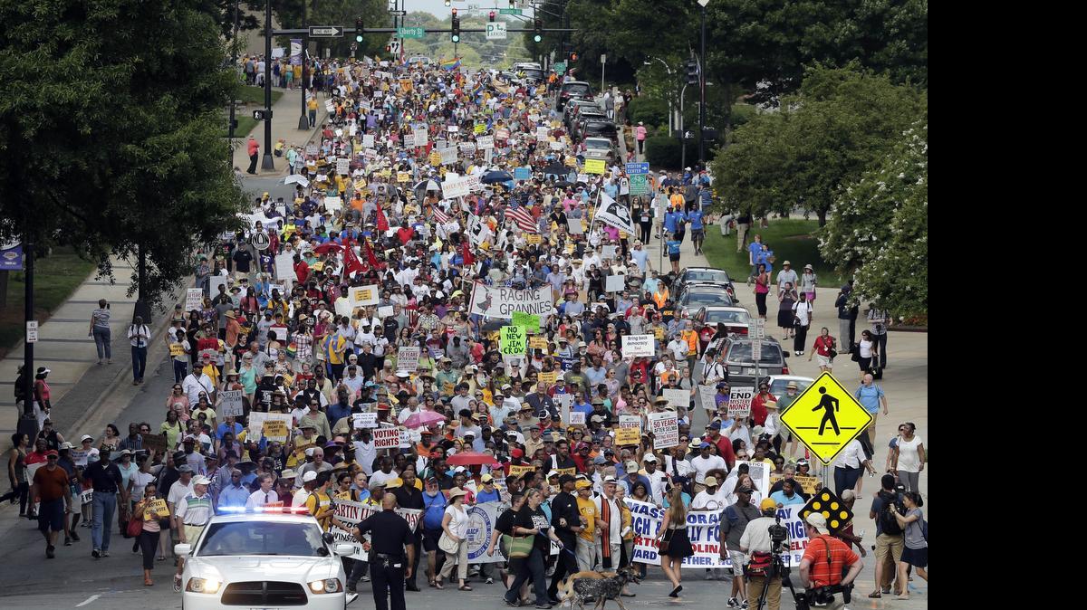 
Demonstrators march through the streets of Winston-Salem, N.C., Monday, July 13, 2015, after the beginning of a federal voting rights trial challenging a 2013 state law. Election law experts say the case could determine how far Southern states can change voting rules after the nation's highest court struck down a portion of the federal Voting Rights Act just weeks before the North Carolina law was passed.
