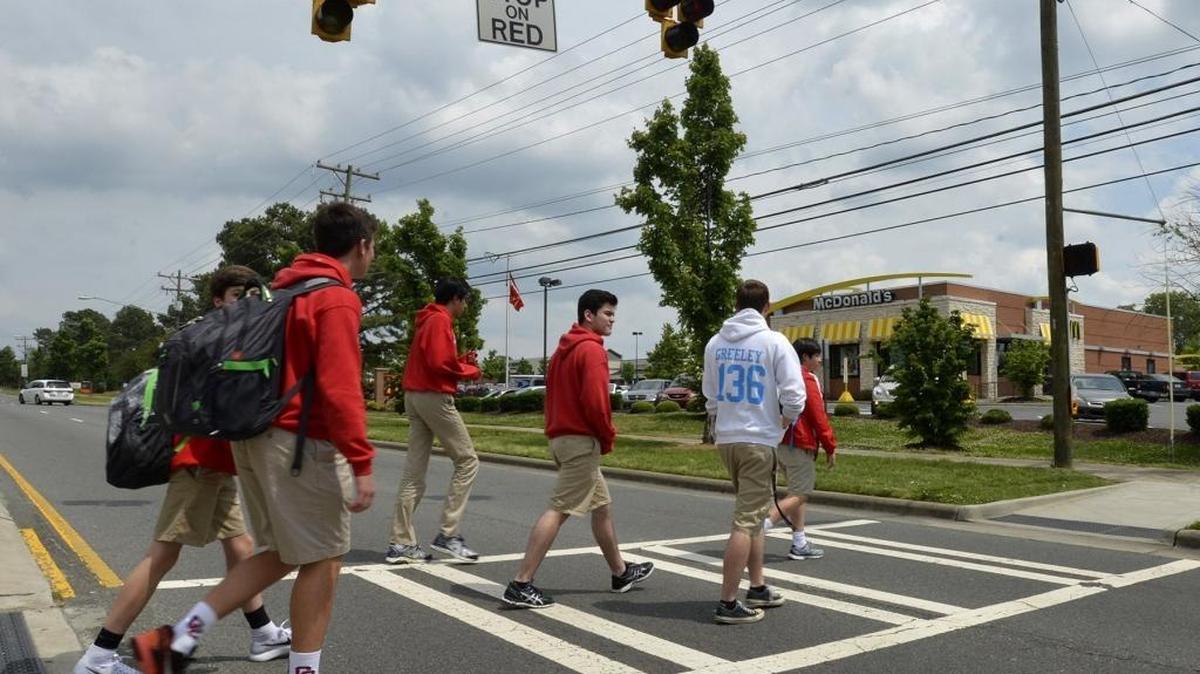 Charlotte Catholic High School students use a crosswalk in front of the school that leads to a McDonald’s in the Carmel Commons Shopping Center, Wednesday afternoon, May 11, 2016. Mecklenburg’s health director has proposed a provocative way to improve the health of teenagers: Restricting fast-food restaurants from opening near high schools