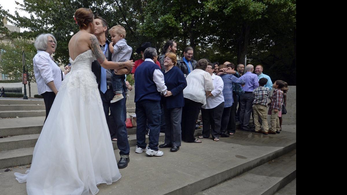 
Five couples, some plaintiffs in the litigation that led to overturning the state’s ban on same-sex marriage, kiss after being declared wedded on the steps outside the Mecklenburg County Register of Deed’s office in Charlotte in 2014.
