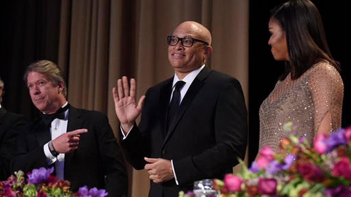 Larry Wilmore, guest host from Comedy Central, waves as he is introduced at the annual White House Correspondents' Association dinner at the Washington Hilton, in Washington, Saturday, April 30, 2016. Major Garrett of CBS News is a left, and Michelle Obama is on the right.
