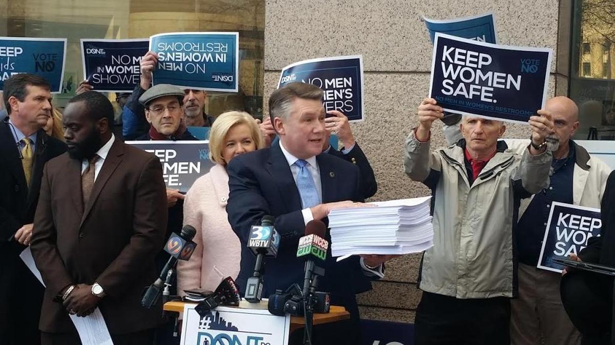 Mark Harris, pastor of the First Baptist Church, held a stack of signatures of people who are opposed to expanding Charlotte’s non-discrimination ordinance.