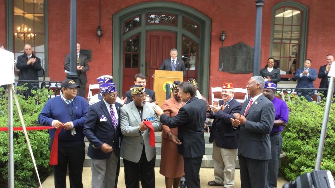 Gov. Pat McCrory, center, and Secretary of Military and Veterans Affairs Cornell Wilson, right, join veterans in cutting a ribbon to open the new Department of Military and Veterans Affairs headquarters in the historic Seaboard Building in downtown Raleigh.