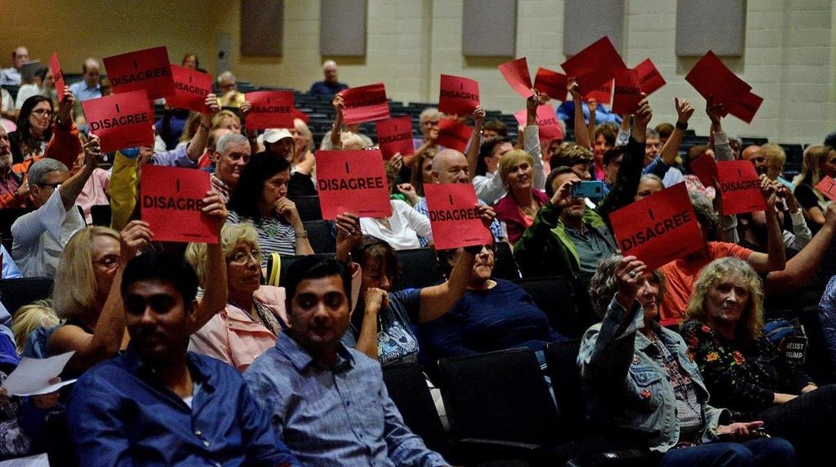 People in the audience hold “I Disagree” signs during U.S. Rep. Robert Pittenger’s town hall Thursday night at Providence High School. The Charlotte congressman has been a big supporter of President Donald Trump. The meeting reflected the deepening divisions across the county as well as liberal rancor toward Trump and a Republican congressman who has been one of his outspoken supporters.