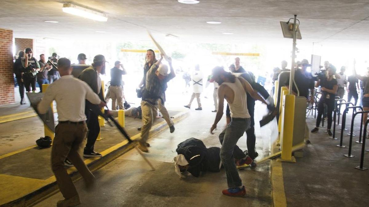 DeAndre Harris, bottom, is assaulted in a parking garage beside the Charlottesville, Va., police station after a white nationalist rally was dispersed by police Saturday.