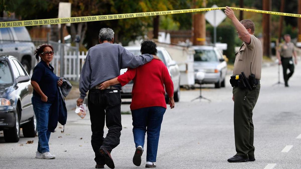 SAN BERNARDINO, CA - DECEMBER 03: A police officer raises police tape to allow residents to enter San Bernadino Avenue, the crime scene where the suspects of the Inland Resource Center were killed. The day before the deadly California shootings, a new North Carolina law took effect that one law enforcement official says clarifies and could even strengthen state background checks for handgun buyers.
