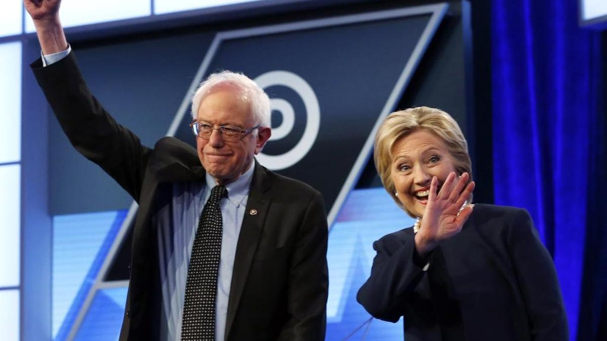 In this March 9, 2016, photo, Democratic presidential candidates, Hillary Clinton and Sen. Bernie Sanders, I-Vt., stand together before the start of the Univision, Washington Post Democratic presidential debate at Miami-Dade College in Miami. Both of the candidates will be in Charlotte on Monday.