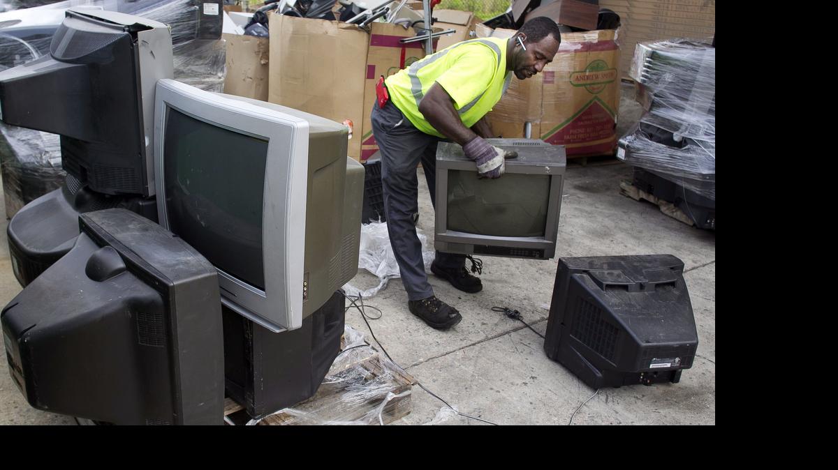 
Charles Snead , an employee at North Wake Multi-Material Recycling Center in Raleigh, moves discarded television sets to a pallet so they can be loaded into a truck on Wednesday. Wake County residents drop off electronics daily to be recycled at the facility. 
