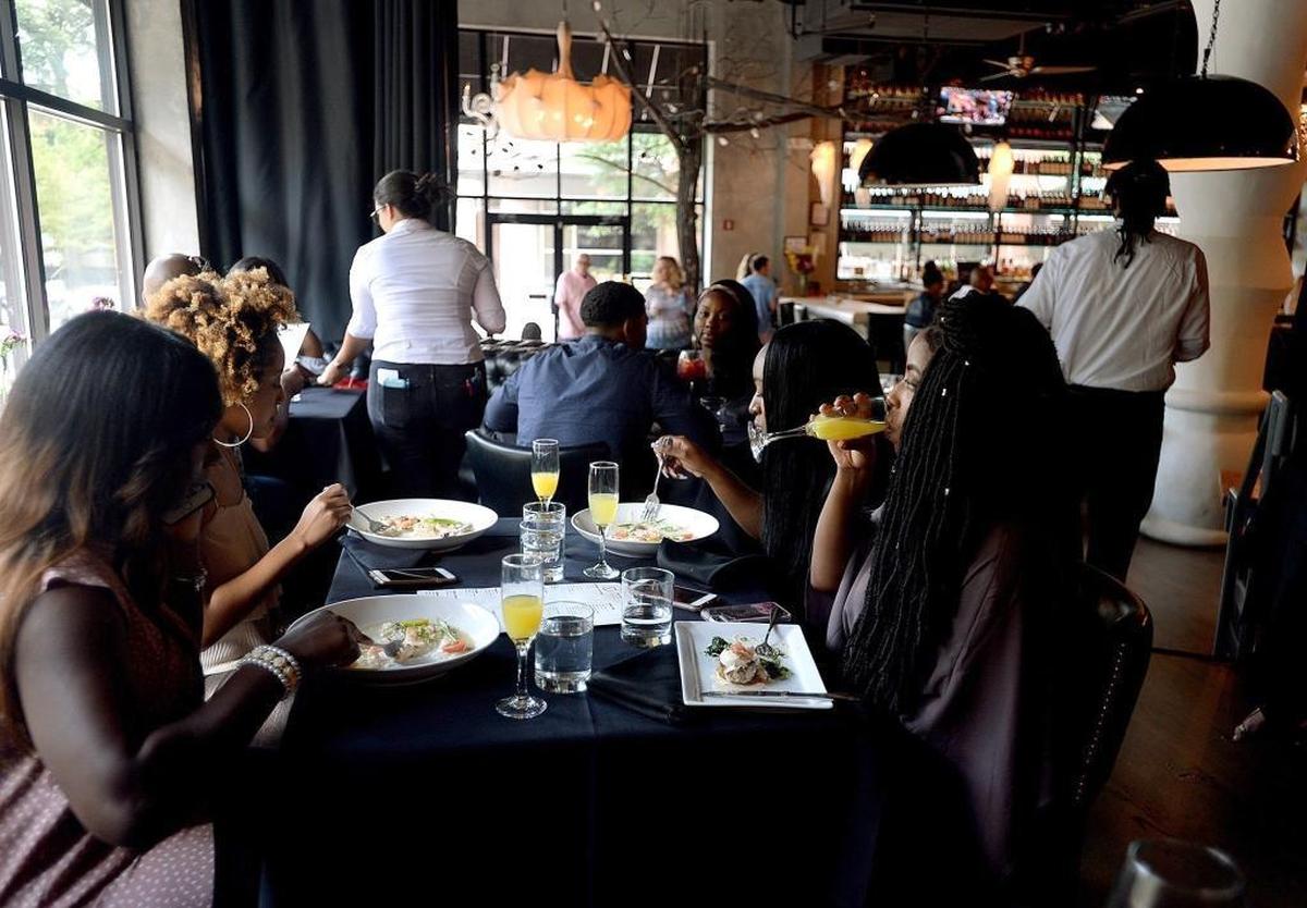Tia Richardson, Venecia Richardson, Quisha Davis and Alexis Generett, left to right, enjoy brunch and mimosas at 5Church restaurant uptown on Sunday. Senate Bill 155, also known as the “brunch bill,” would allow restaurants to serve alcohol before noon if it passes.
