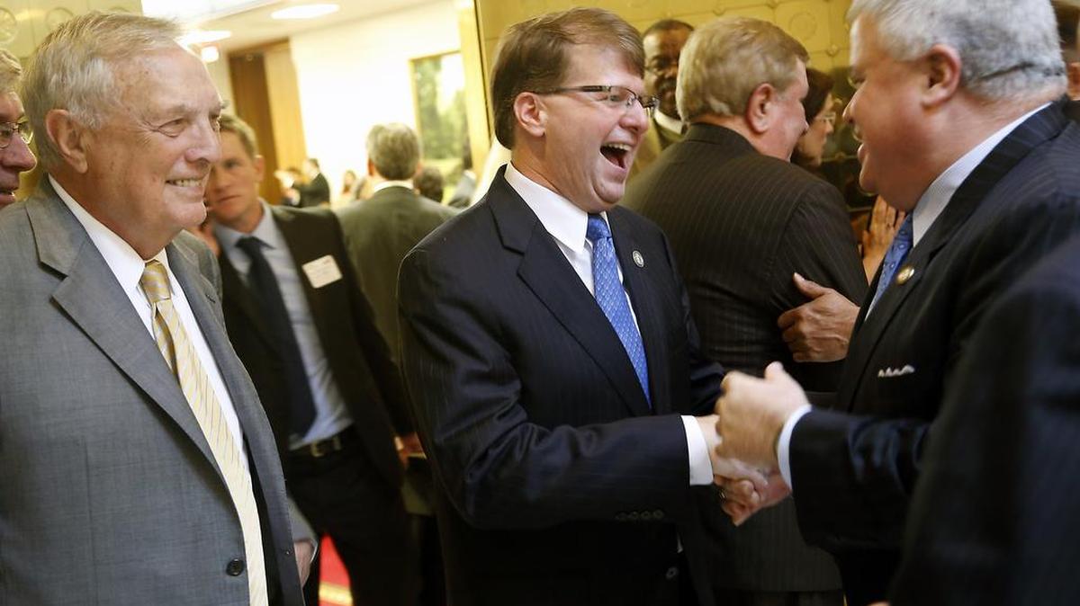 Chairman of a House judiciary committee, Rep Leo Daughtry, left, and Sen. Tom Apodaca, right, talk with N.C. Chief Justice Mark Martin, center, after he delivered a State of the Judiciary address before the N.C. General Assembly on Wednesday, March 4, 2015, at the Legislative Building in Raleigh.