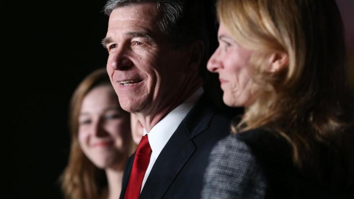 Roy Cooper and his wife Kristin Cooper, right, along with family relish in Cooper’s claimed victory over incumbent Governor Pat McCrory on election night.