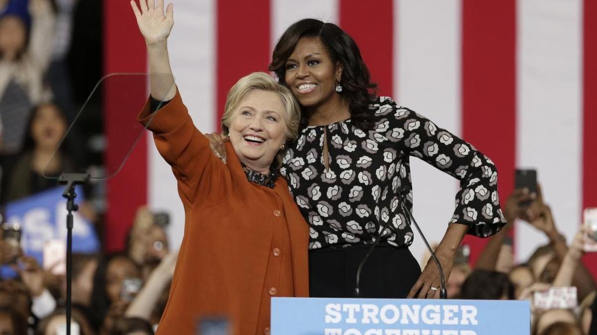 Democratic presidential candidate Hillary Clinton, accompanied by first lady Michelle Obama, greet supporters during a campaign rally in Winston-Salem, N.C., Thursday, Oct. 27, 2016.