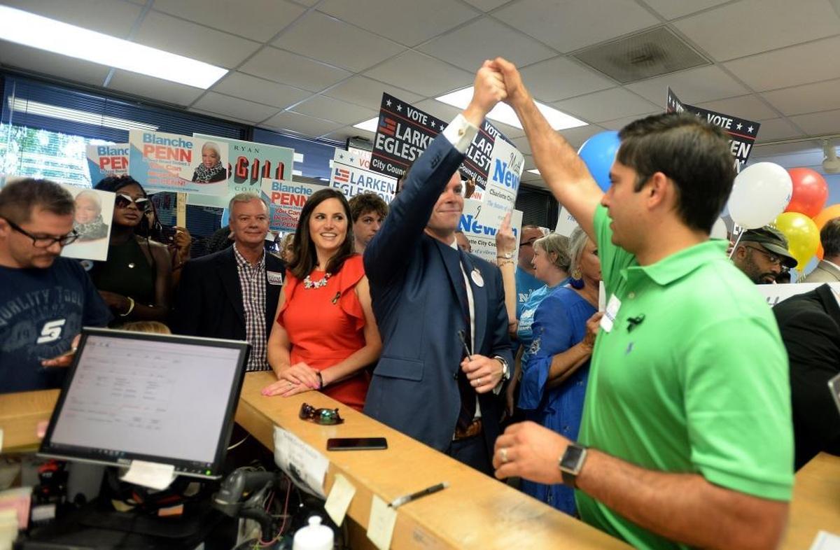 Candidates for Charlotte City Council Parker Cains, left, and Tariq Scott Bokhari, right, celebrate after filing Friday for the upcoming election.