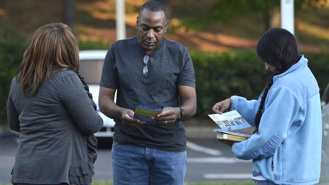 
Shaftina Snipes (left), working for David Howard and Diana Wolff (right), working for Mo Idlibby hand pout materials to voter Alex Williams in front of the University City Regional Library, precinct 141. Voter turnout is expected to be low during the primary election on Tuesday September 15, 2015. Precinct 141, the University City Regional Library, is an early voting site which can confuse voters who have voted there in the past. A number have been redirected to there home precinct. 
