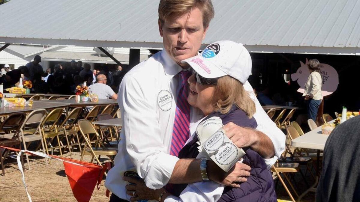 Republican mayoral candidate Edwin Peacock hugs Cecy Ramirez, wife of the late former Mecklenburg Commissioner Dan Ramirez, at the annual Mallard Creek BBQ event at Mallard Creek Presbyterian Church, which feed folks' need for pulled pork, Brunswick stew and politicians.