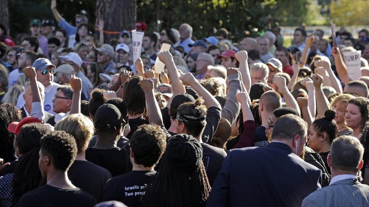 Protesters raise their fists as they are escorted from a campaign event with then-Republican vice presidential candidate Mike Pence at Catawba College in Salisbury, N.C., Monday, Oct. 24, 2016.