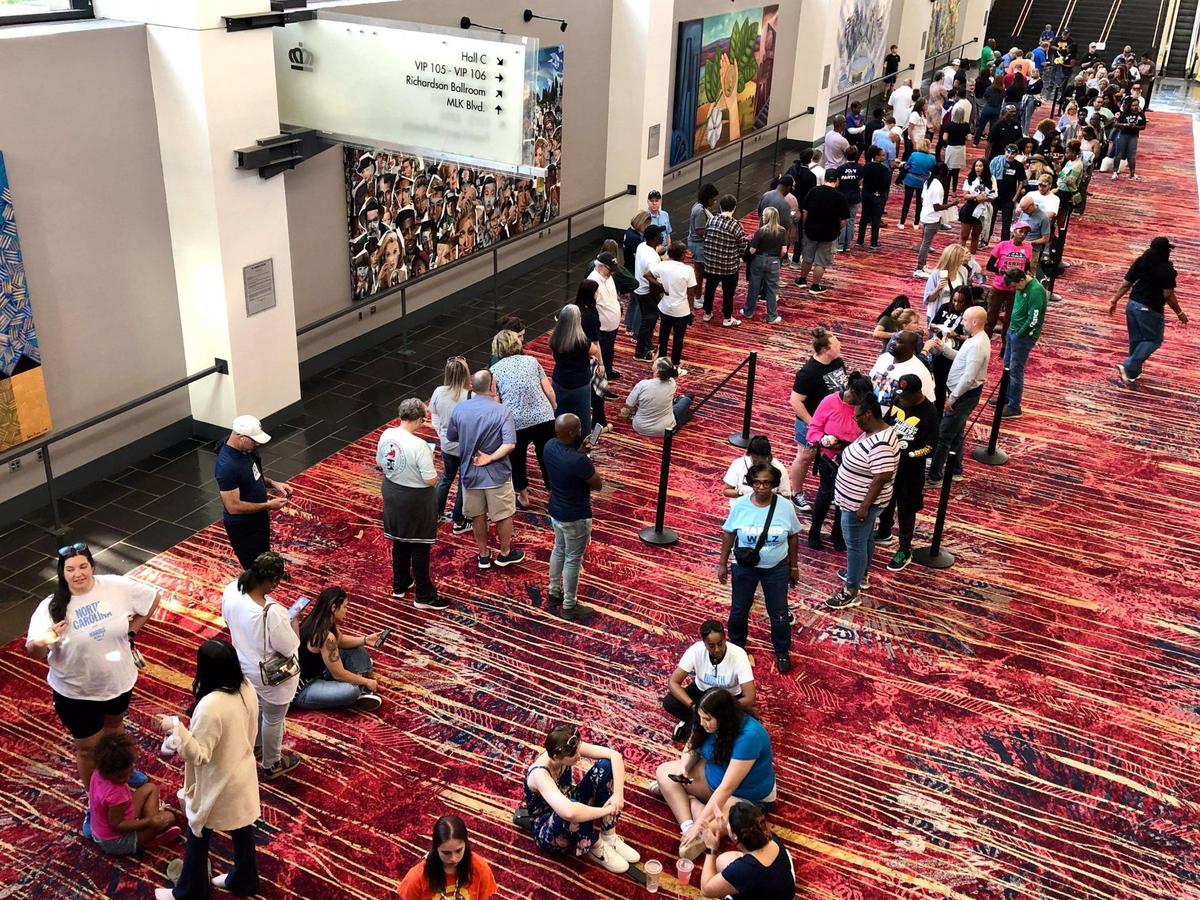 Lines of Harris and Walz supporters line up for entrance to former President Barack Obama’s rally.