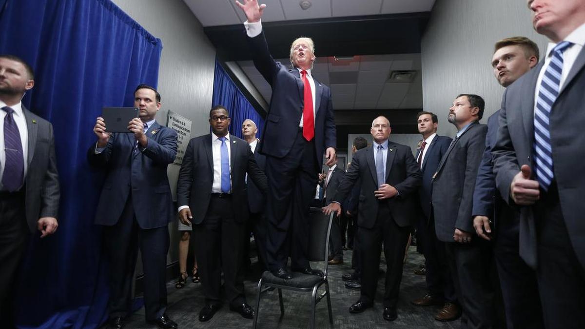 Donald Trump stands on a chair to wave to supporters after speaking during a rally at the Greenville Convention Center in Greenville, N.C., on Tuesday. The GOP presidential nominee urged North Carolinians to vote and promised to bring back jobs.