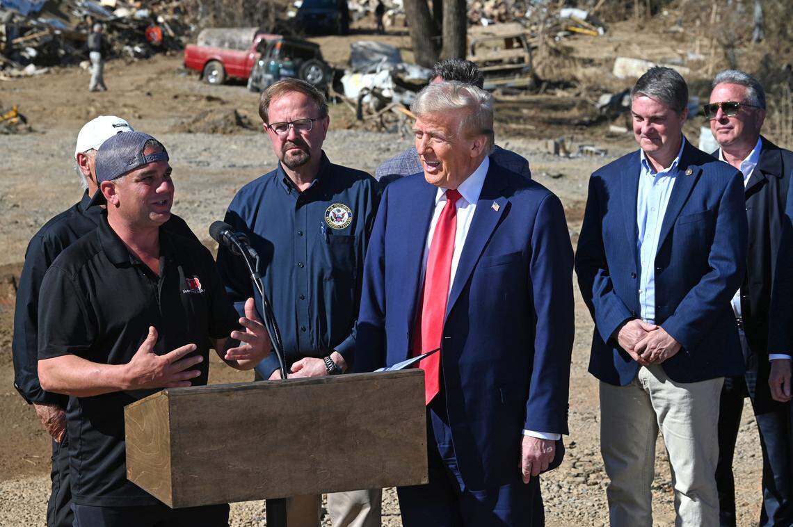 Local Swannanoa, NC business Brian Burpeau, left, addresses the media gathered for former President Donald J. Trump, right, during the former president’s tour of damage caused in the local area by Hurricane Helene.
