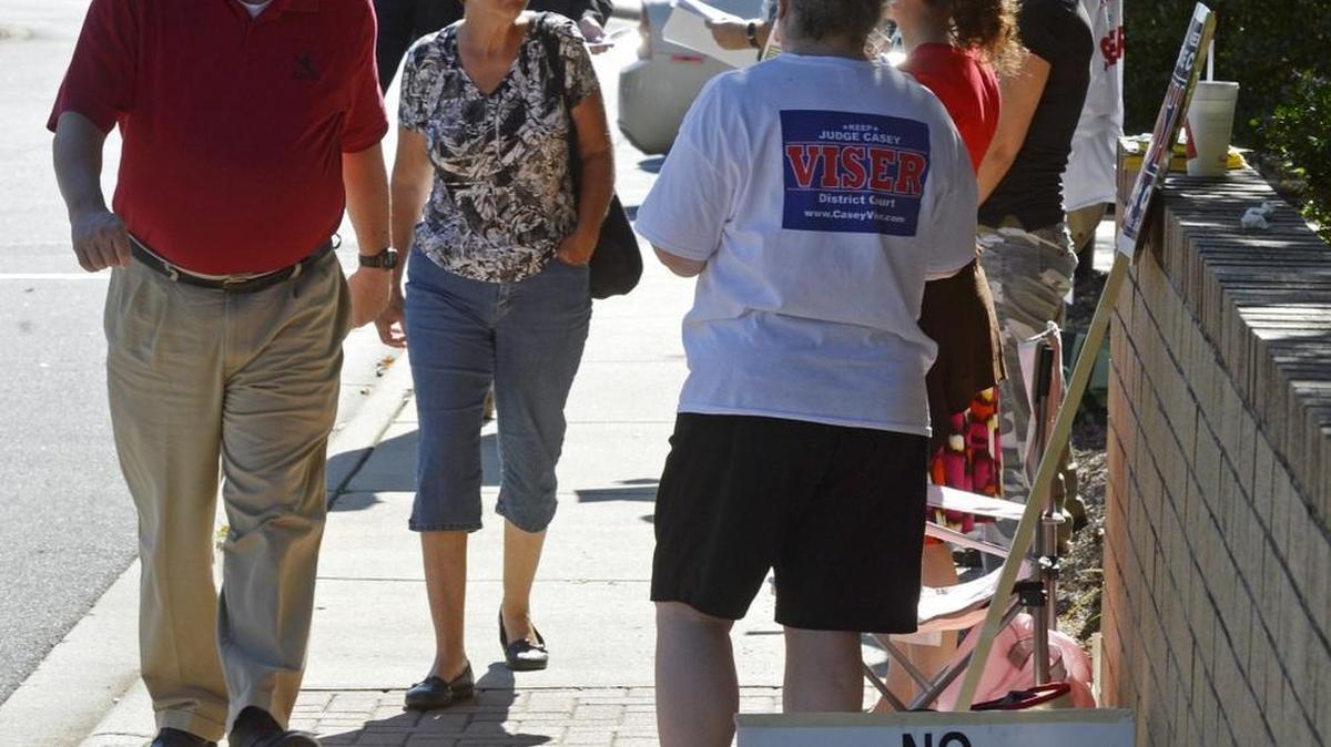 
Early voters are greeted by campaign workers as the arrive at the South County Regional Library on Rea Road, Monday afternoon, Oct. 27, 2014. 
