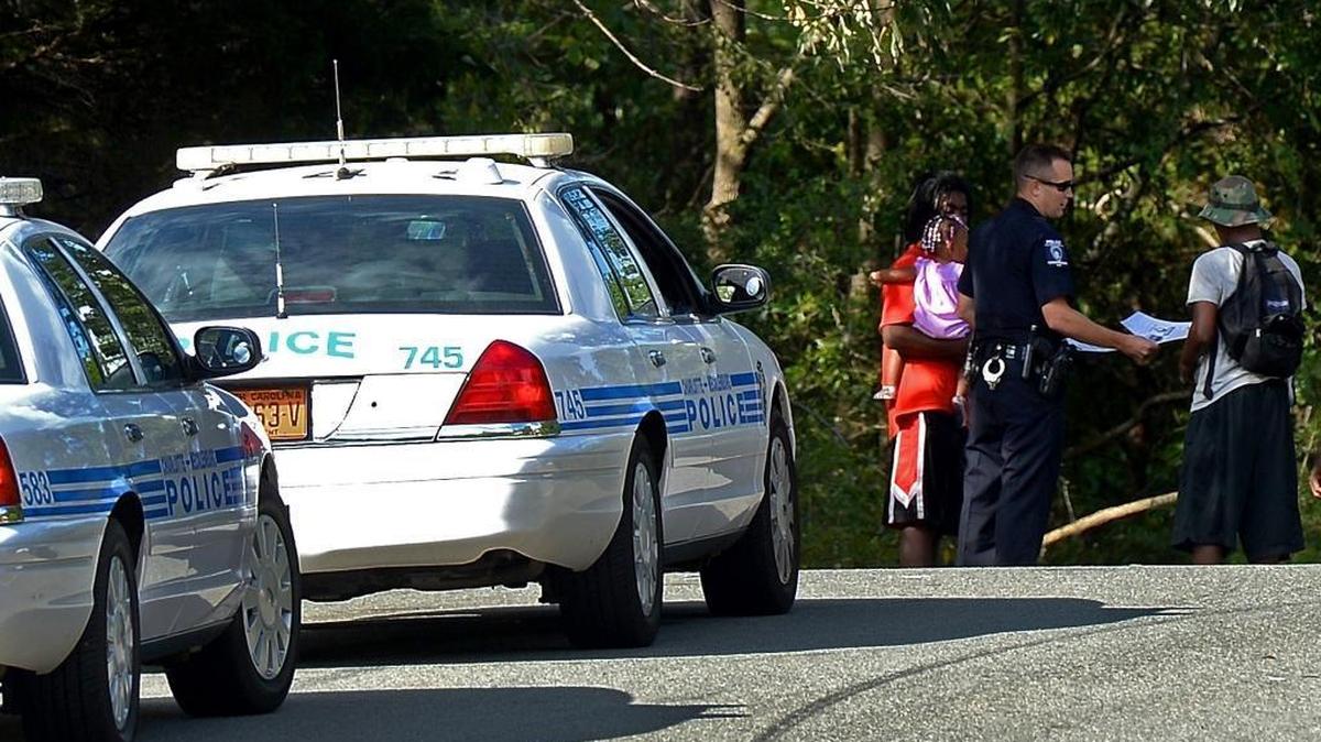 
A Charlotte Mecklenburg police officer hands out flyers to people in the Springfield subdivision on Tuesday, September 8, 2015. Police were patrolling the area looking for assistance in solving a shooting on Saturday night at 6824 Fieldvale Drive that resulted in the death of seven-year old Kevin Antonio Calderon Rodas.
