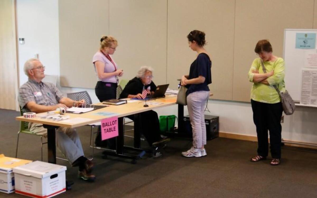 From left, Estes Hills precinct workers Barron Housel, Chief Judge Calyx Harris and Karen Piplani help check voters in during primary-election voting Tuesday, June 7, 2016 at the Chapel Hill Public Library.