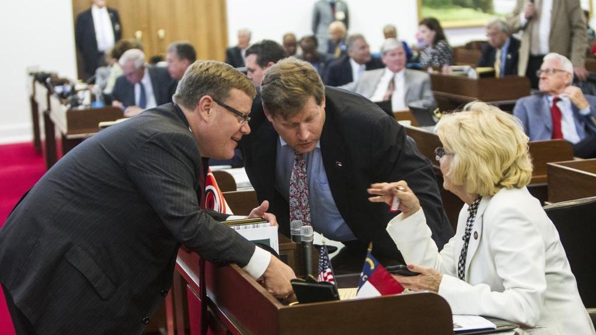 Speaker Tim Moore, left, talks with Reps. Nelson Dollar and Linda Johnson during a House session Wednesday, August 5, 2015 at the Legislature Building. State legislators are considering further changes to the tax policy.