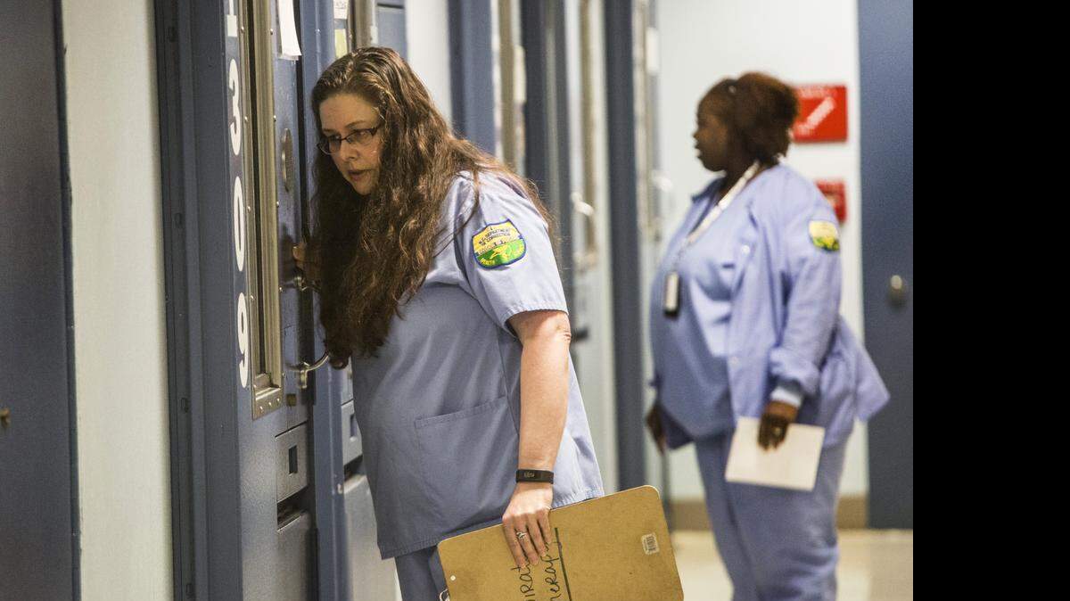 
Contract nurse Wendy Vaught, foreground, checks on a prisoner Thursday, April 16, 2015 at North Carolina Central Prison Regional Medical Center and Mental Health Facility. Agencies, like the Department of Public Safety, rely heavily on personal services contracts to hire medical staff because it's difficult to recruit staff healthcare workers in the prison system. 
