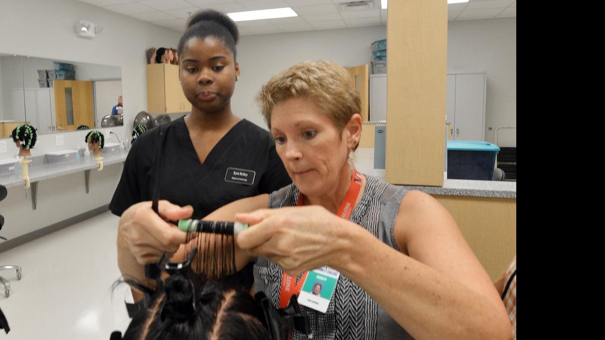 
Cosmetology instructor Leah Lockamy helps Kyra Holley, 16, with rollers in the cosmetology lab at the Vernon Malone College and Career Academy – one of eight Cooperative and Innovative High Schools that would receive funding under the N.C. House budget proposal.
