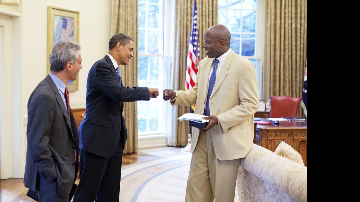 
President Barack Obama and personal aide Reggie Love fist bump as Chief of Staff Rahm Emanuel looks on, in the Oval Office on June 16, 2009.
