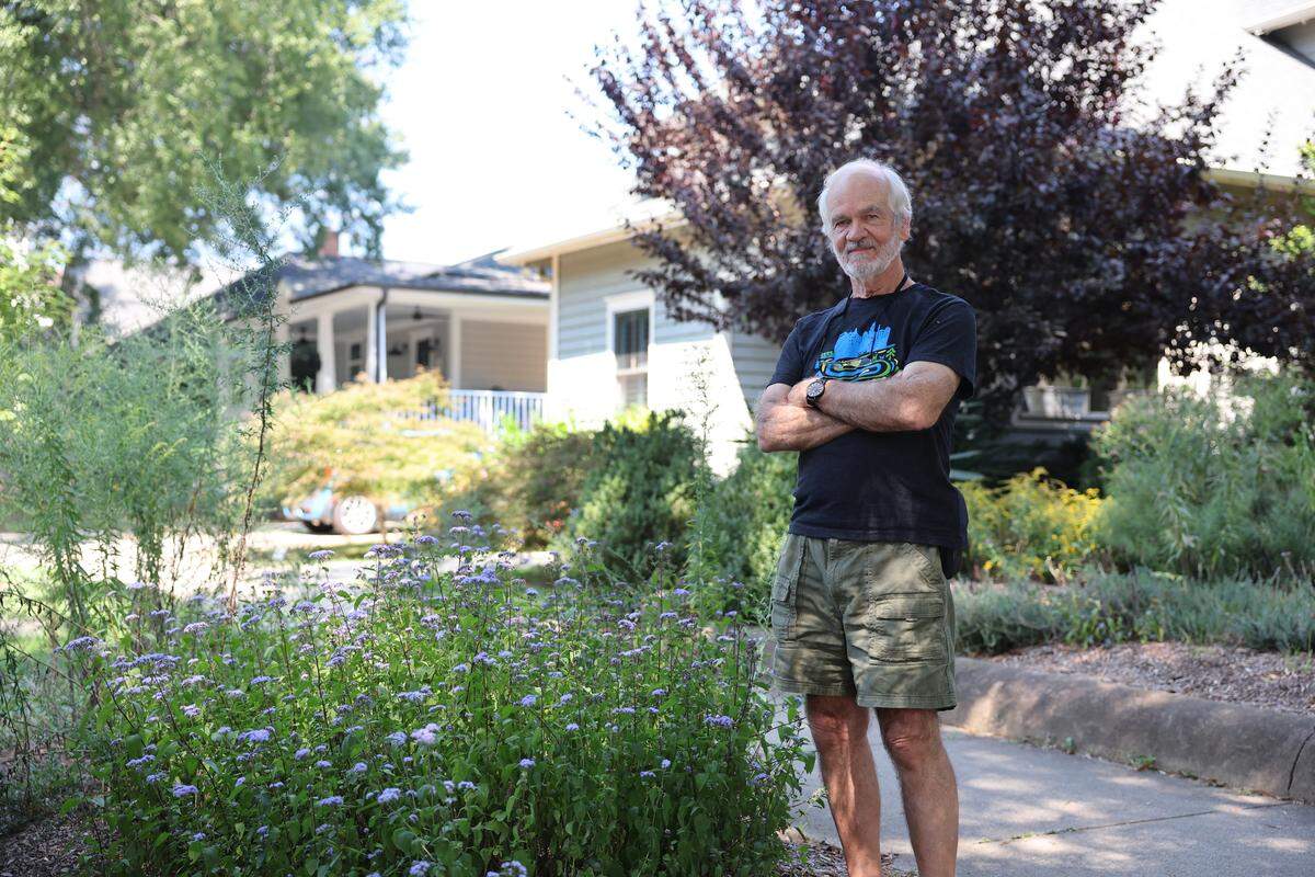 Lou Lesesne stands near part of his lawn that has pollinating flowers Wednesday, Sept. 24, 2025 in Charlotte.
