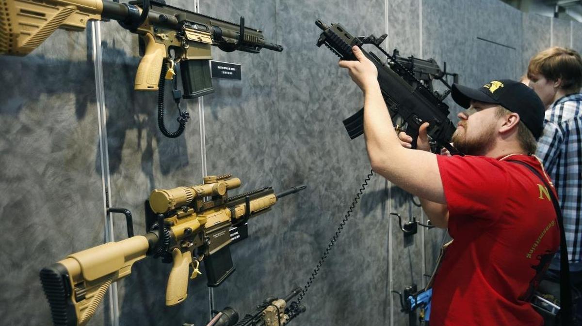 A would-be buyer inspects a weapon at a Las Vegas gun show.