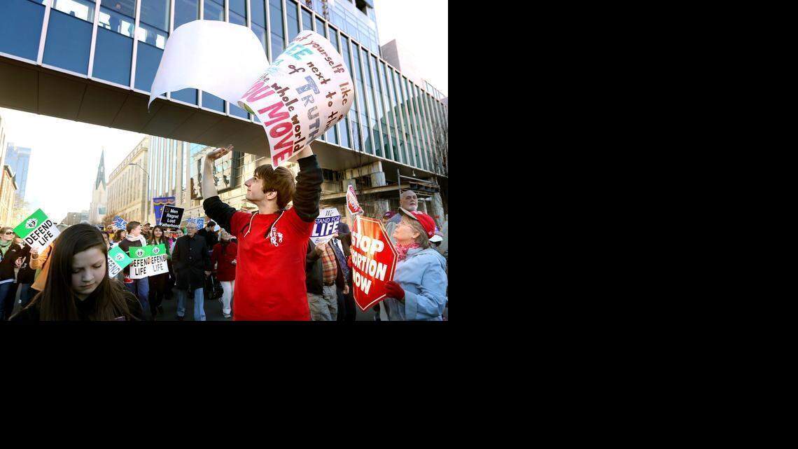 
Daniel White, 20, of Raleigh, waves to visitors of the North Carolina Museum of Natural Sciences as White and more than 1,500 community members march down South Salisbury Street during the March for Life in downtown Raleigh in in January. 
