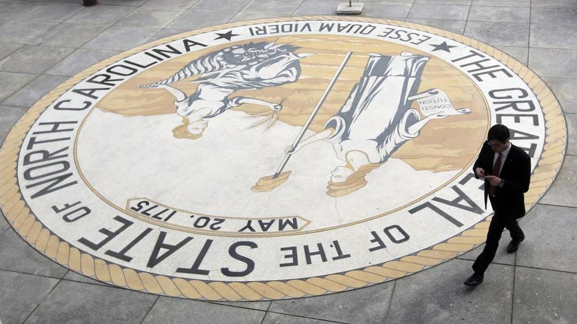 In this 2013 file photo, a man walks alongside the state seal at the entrance to the Legislative Building in Raleigh.
