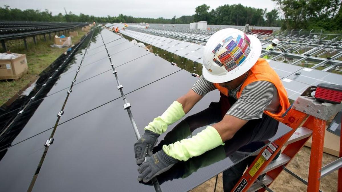 Lario Mandez secures solar modules into place on Wednesday, May 18, 2016 in Lumberton, N.C. Strata Solar is installing 60,000 modules on a 43 acre site in Robeson County. The farm should be up and running in about a month.
