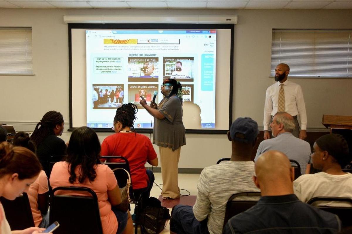 Maria Macon, left, and Rhandu Adams of the Council of Elders speak during a May expunction clinic in Charlotte. More than 1,300 people registered to get help to remove a crime from their criminal record. On Saturday, the first 115 people found eligible for the service will fill out the paperwork with the help of volunteer attorneys