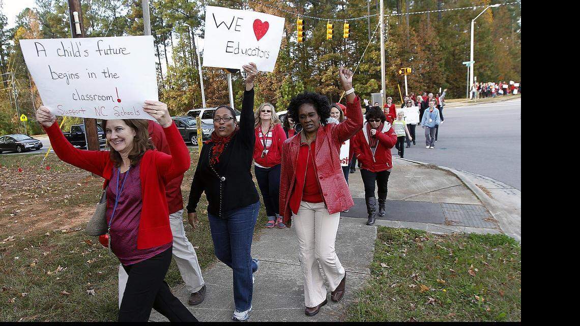 
Teachers, students and other protestors march from Middle Creek HS to West Lake Middle School in Apex on Nov. 4, 2013. Protestors wore red and held signs as part of a statewide network of teacher walk-ins. On Tuesday, June 5, 2015, a divided NC Appeals Court said lawmakers' attempt to end teacher tenure was unconstitutional. 
