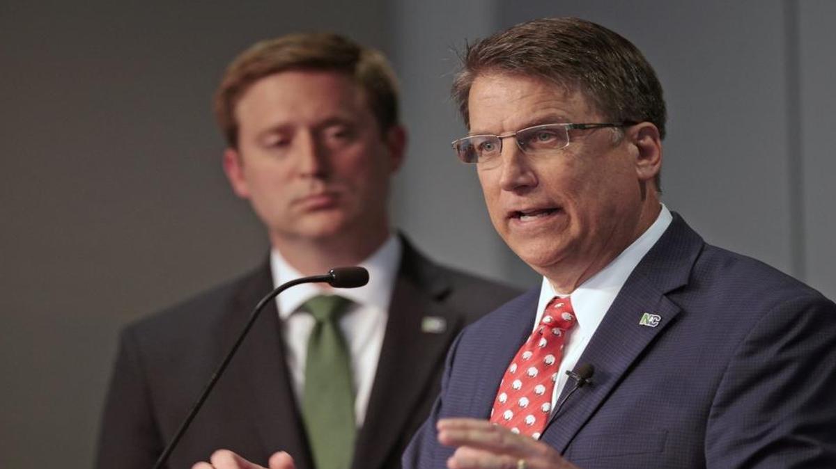 From left, N.C. Budget Director Andrew Heath listens as Gov. Pat McCrory gives overall details of the Governor's 2016-17 state budget during a press conference Friday morning, April 22, 2016, at the North Carolina National Guard Joint Task Force headquarters in west Raleigh.