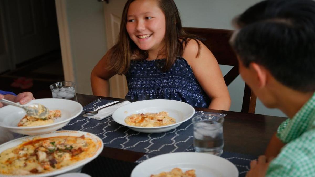 Mena Choi, 10, laughs with her father, Steve Choi, during dinner in their Chapel Hill, N.C., home on July 8, 2016.