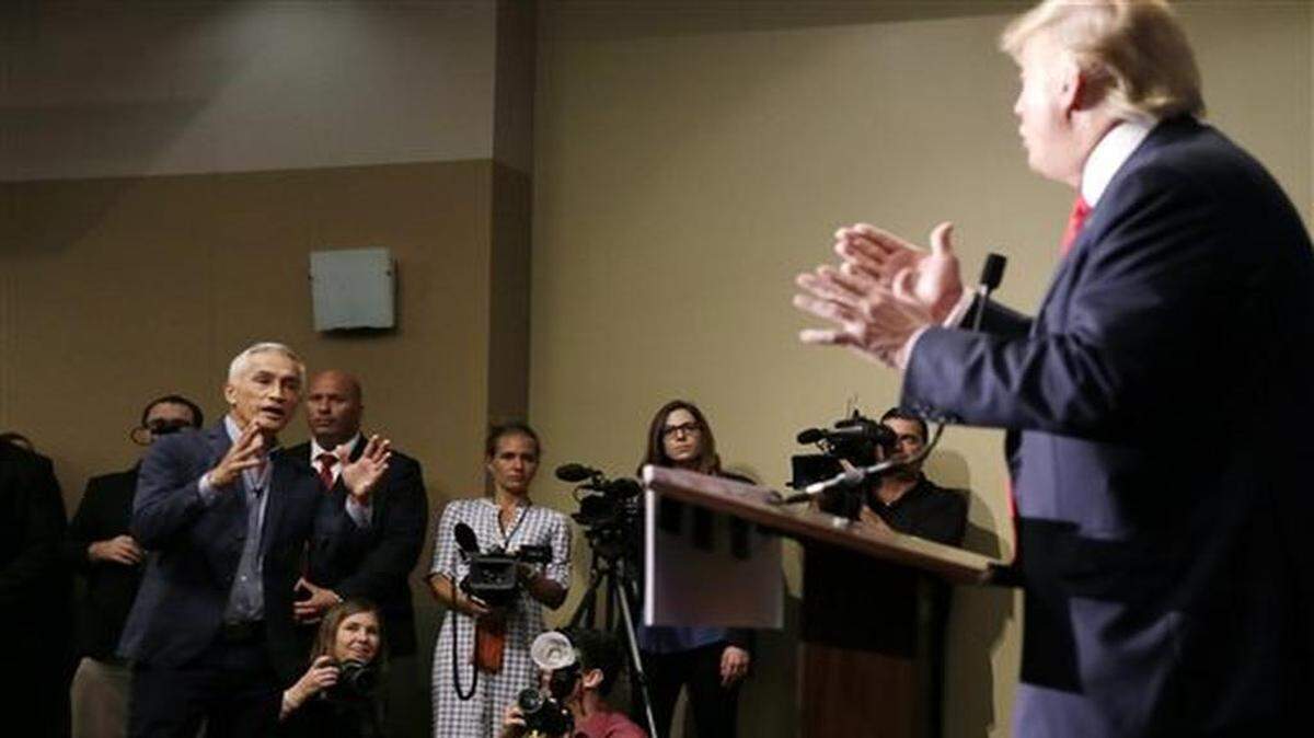Miami-based Univision anchor Jorge Ramos, left, asks Republican presidential candidate Donald Trump a question about his immigration proposal during a news conference, Tuesday, Aug. 25, 2015, in Dubuque, Iowa. Ramos was later removed from the room.