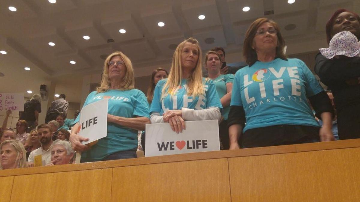 Anti-abortion protesters attend Monday night’s City Council meeting to criticize the city for considering adding no-parking signs on Latrobe Drive, outside an abortion clinic.
