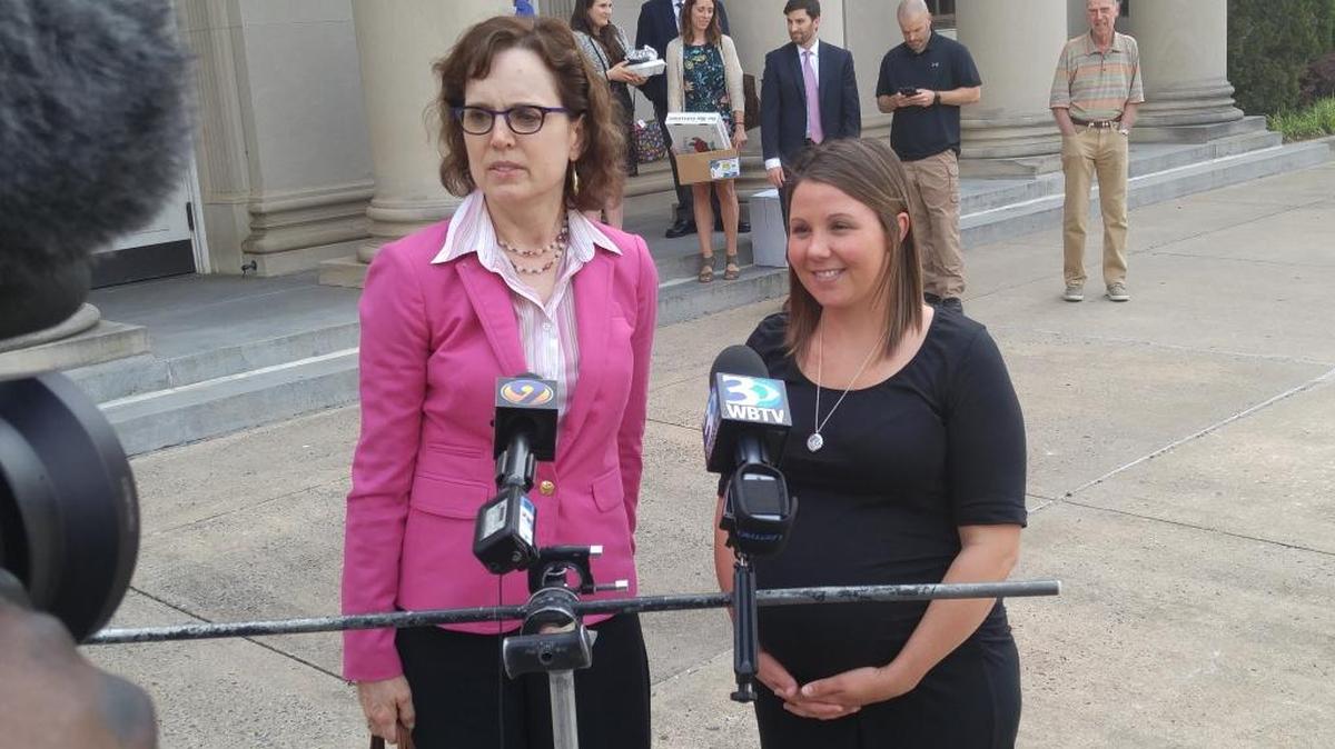 Former fire investigator Crystal Eschert, right, and her attorney, Meg Maloney, speak to reporters after a jury awarded Eschert $1.5 million in her lawsuit against the city.