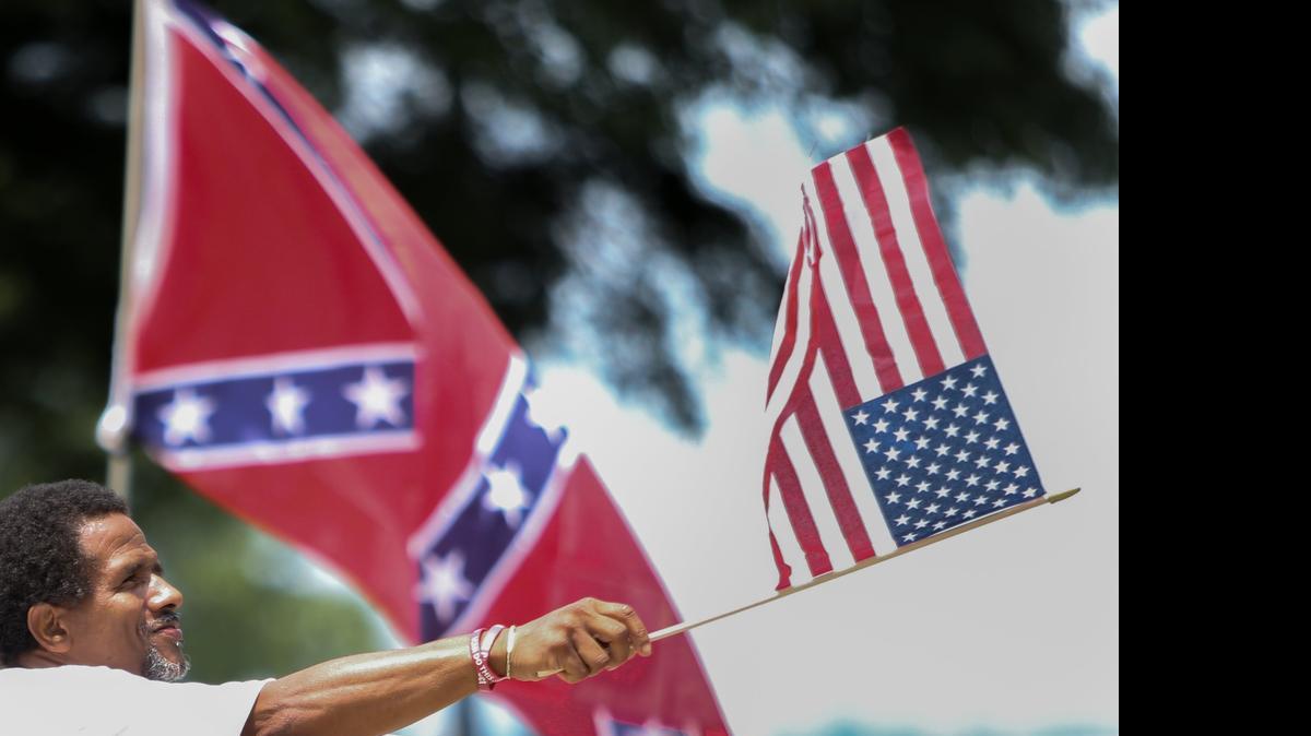 
Thomas Wiggins, of Columbia, waves an American Flag while showing support to take the Confederate flag off the South Carolina Statehouse grounds on Tuesday.
