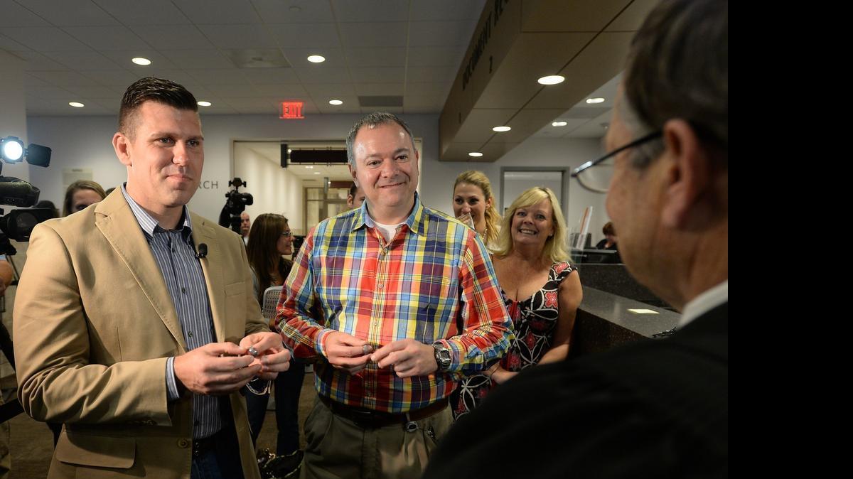 
Chad Biggs (left) and his fiance, Chris Creech say their wedding vows in front of Wake County magistrate Dexter Williams at the Wake County Courthouse in Raleigh, N.C. Friday, October 10, 2014.
