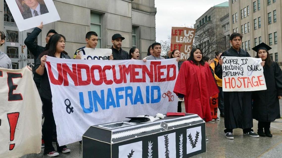 
Immigration activists chant behind a cardboard coffin on the front steps of the Attorney General's office at in 2014. Legislation approved in the state Senate would ban local governments from refusing to enforce immigration laws.
